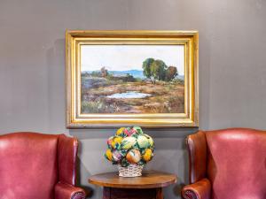 圣巴巴拉阿珀姆酒店的一张桌子上一幅带果子花瓶的田野画