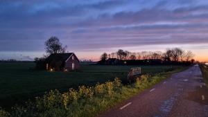 阿姆斯特丹Guesthouse, City Farmer- Amsterdam, lodge with a skyline view的公路旁田野中间的房子