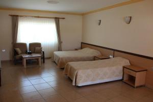 法马古斯塔Kaplica Hotel的酒店客房设有两张床和窗户。