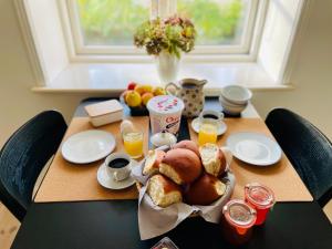 尼克宾法尔斯特Strandby 1847 B&B的餐桌,早餐包括面包和橙汁
