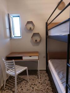 阿尔米洛波塔莫斯Vιtamin Sea apartment 8, Απολαυστική διαμονή στον Αλμυροπόταμο!的一间卧室配有一张桌子和一张双层床。