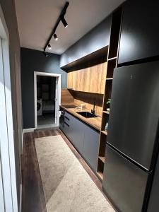 地拉那Amazon House 8的厨房配有黑色冰箱和水槽