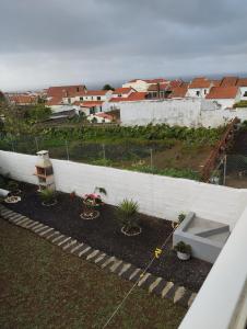 蓬塔德尔加达Casa do Lavrador的后院种植了植物,设有白色的围栏