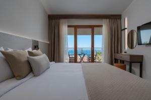 佩科霍里Alia Palace Hotel - Adults Only 16+的一间卧室设有一张床,享有海景