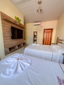 ItaitubaHotel Campos的酒店客房设有两张床和一台平面电视。