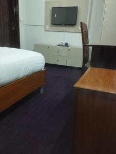 伊斯兰堡Trail Residency的卧室配有一张床,墙上配有电视。