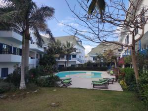 圣玛丽亚Residence Amanda with pool的一个带长椅和棕榈树的游泳池的度假酒店