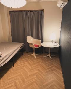 SaikiHostel UND BASE的配有床、桌子和椅子的房间