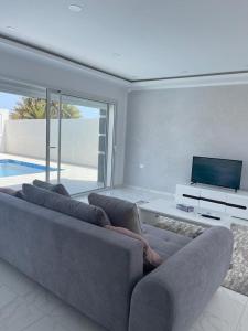DjerbaSuperbe villa avec piscine sans aucun vis à vis的带沙发和电视的客厅