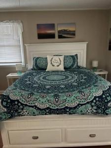 海洋岛海滩Tipsea Turtle的一间卧室配有一张带绿色和白色棉被的床