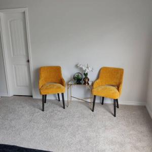 沃思堡Maison EMN的两个橙色椅子和一张桌子