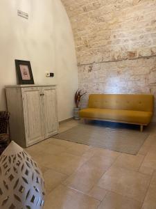 莫诺波利Masseria I Raffi b&b的砖墙房间里一张黄色的沙发