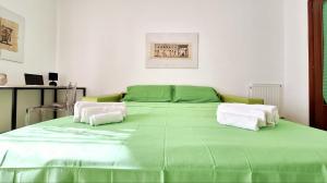 里波斯托Casa Iolanda的一张绿色的床,上面有两条白色毛巾