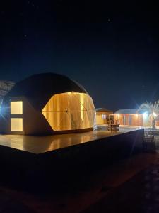 亚喀巴Wadi Rum Marcanã camp的夜晚有灯的圆顶形建筑