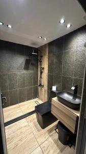 阿杰隆The Lodge Ajloun的一间带黑色水槽和淋浴的浴室