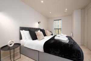 利兹Luxury Serviced Penthouse - City Centre - En Suite Bedrooms - Free Netflix的一间卧室配有一张大床,提供黑白枕头