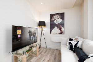利兹Luxury Serviced Penthouse - City Centre - En Suite Bedrooms - Free Netflix的客厅配有白色沙发和平面电视。