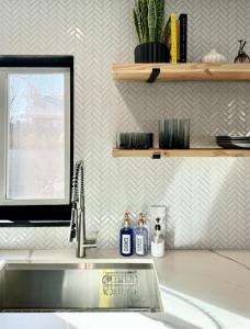 里诺Sunshine House的厨房水槽配有两瓶肥皂和窗户