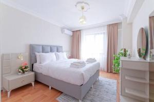 伊斯坦布尔Spacious Duplex With Stunning Halic Views的白色卧室设有一张大床和镜子