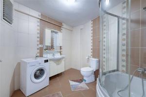 伊斯坦布尔Spacious Duplex With Stunning Halic Views的浴室配有卫生间、盥洗盆和洗衣机。
