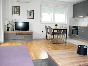 柳布什基An apartment M & K - 70 m2的厨房配有桌椅和电视。