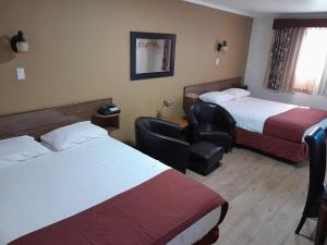 克兰布鲁克Travellers Motel的酒店客房,配有两张床和椅子