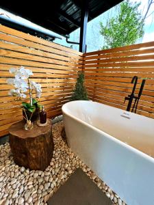 达沃市Cozy Tiny Home with Outdoor Hot Tub in City Center的带浴缸的浴室,旁边是树 ⁇ 