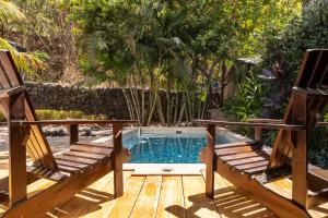 马塔帕洛Casa Mono del Río的一个带两把椅子的庭院和一个游泳池