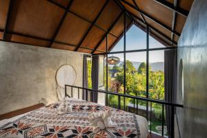 金塔马尼Mountain Peak Kintamani的一间卧室设有一张床和一个大窗户
