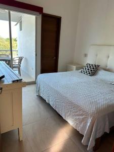 巴亚尔塔港Casa hermosa y acogedora en condominio privado的一间卧室配有一张床、一张书桌和一个窗户。