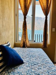 圣佩德罗拉拉古纳Nicolas House #2 with Lake Atitlán View的一间卧室设有一张床和一个大窗户
