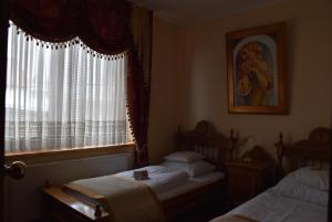 采列格兰德酒店的一间卧室设有两张床和窗户。