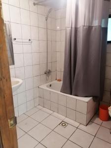 FreireCisnes del tolten的浴室配有浴缸和淋浴及浴帘