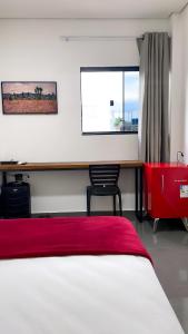 里约布兰科Cubo Hotel的一间卧室配有一张床、一张书桌和一个窗户。