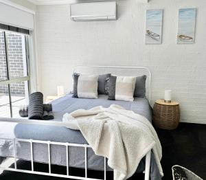 莱克斯恩特伦斯Driftwood Townhouse - Waterfront-Central Location的一间卧室配有一张带蓝色床单和枕头的床。
