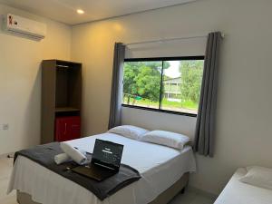 里约布兰科Cubo Hotel的一间卧室,床上配有一台笔记本电脑,设有窗户