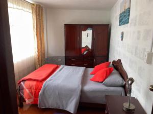 帕帕亚克塔Hermoso departamento en el corazón de Papallacta的一间卧室配有一张带红色枕头的床