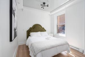 蒙特利尔Penfield Suites的白色的卧室设有床和窗户