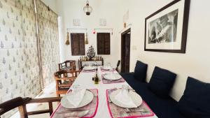 斋浦尔Mosaics Guest House的一间带桌子和沙发的用餐室