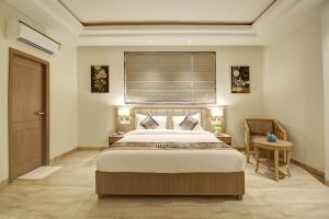 新德里Hotel AMBS suites A family Hotel Near Delhi Airport的一间卧室设有一张大床和一个窗户。