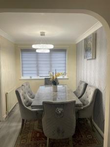 Mansewood3-Bedrooms House in Thornliebank Glasgow的一间带桌椅和吊灯的用餐室