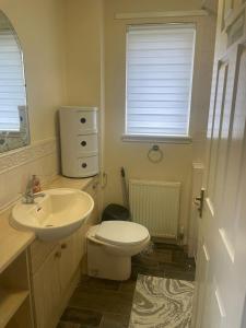 Mansewood3-Bedrooms House in Thornliebank Glasgow的浴室配有白色卫生间和盥洗盆。