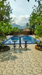 贡布Jasmine Resort Kampot的游泳池前的野餐桌