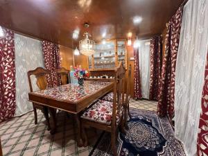 斯利那加Houseboat wild rose的一间带木桌和椅子的用餐室