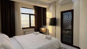杜尚别Hotel Panorama的卧室配有白色的床和窗户。