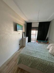 卡萨布兰卡Appart neuf calme et bien équipé的卧室配有一张床,墙上配有电视。