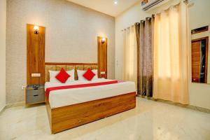 齐拉克普尔Super OYO Flagship Hotel Elista的一间卧室配有一张带红色枕头的大床