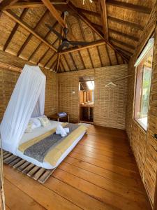 卡里蒙贾瓦漂浮天堂旅馆的铺有木地板的客房内设有一间卧室和一张床。