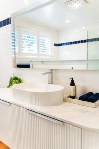 纽波特Newly renovated 4 bedroom home in Newport with Pittwater views的白色的浴室设有水槽和镜子
