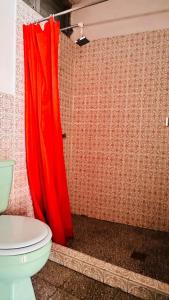 帕纳哈切尔Royal Palace Hostal的浴室设有毗邻卫生间的红色淋浴帘